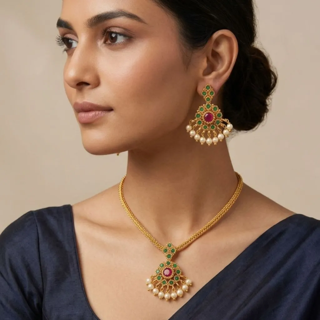 Model wearing traditional gold flat chain necklace with pendant and matching earrings